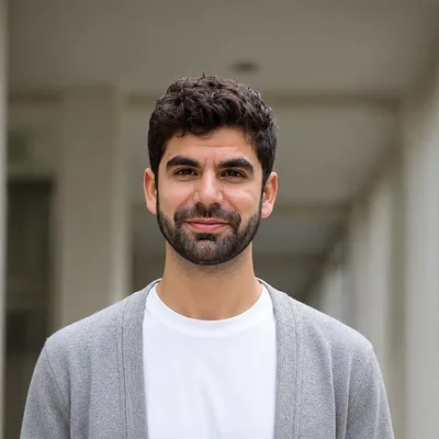 Danny Seabra, smiling, in a white T-shirt and grey cardigan